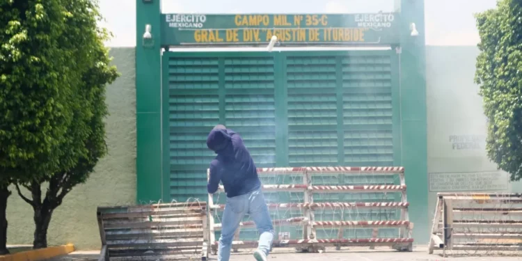 Normalistas arremeten con petardos contra batallón general de Iguala y exigen justicia por los 43